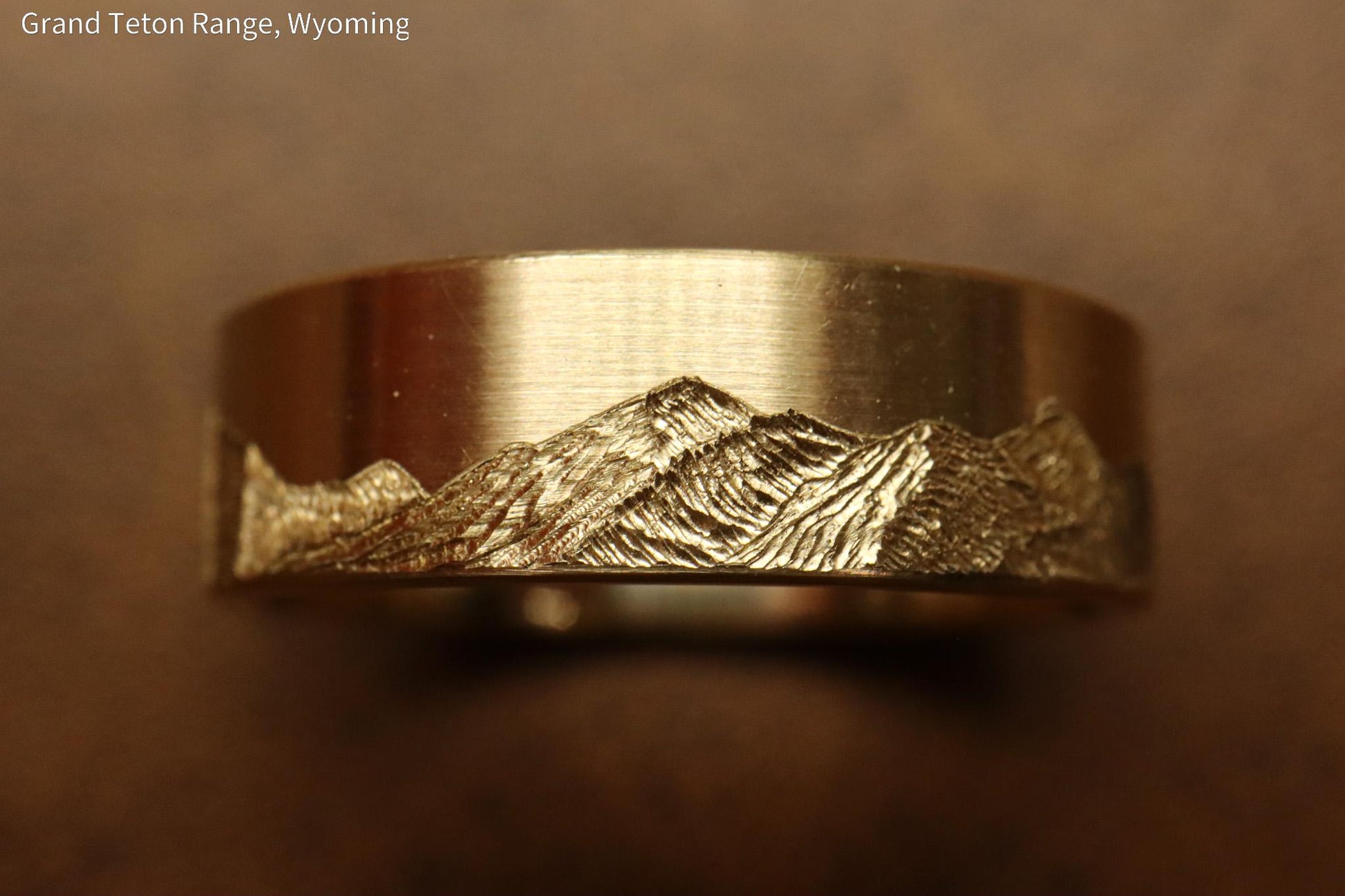 Grand teton mountain range, hand carved on to 14k Yellow gold ring. 6mm wide with comfort fit profile